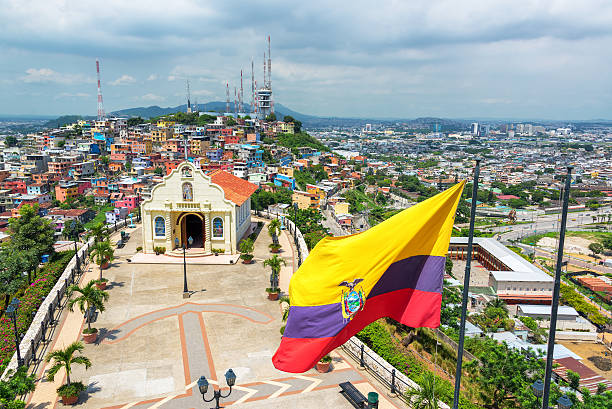 Ecuadorian flag on top of Santa Ana hill with a church and the city of Guayaquil visible in the background in Ecuador