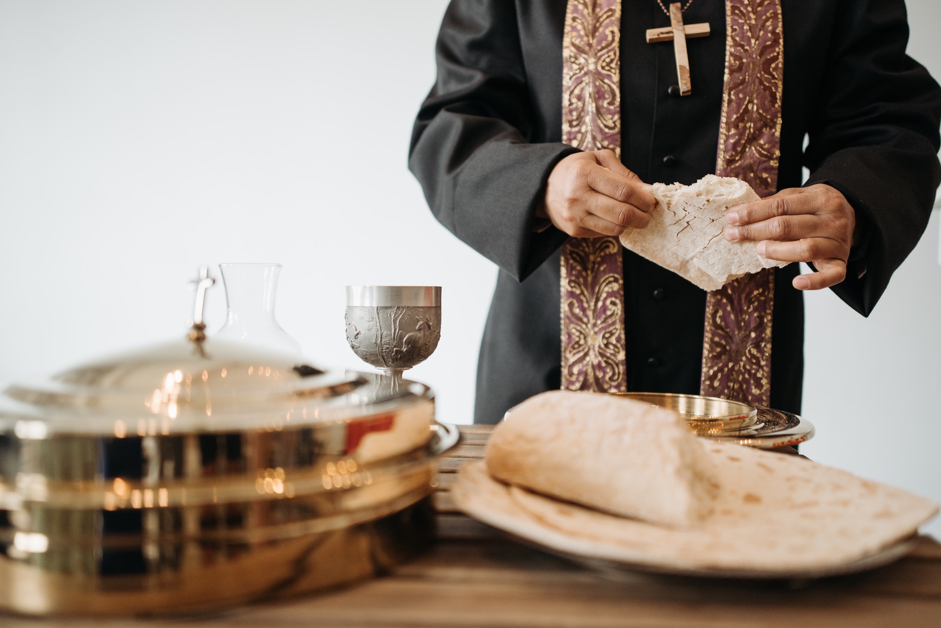 A priest preparing the Eucharist with bread and wine