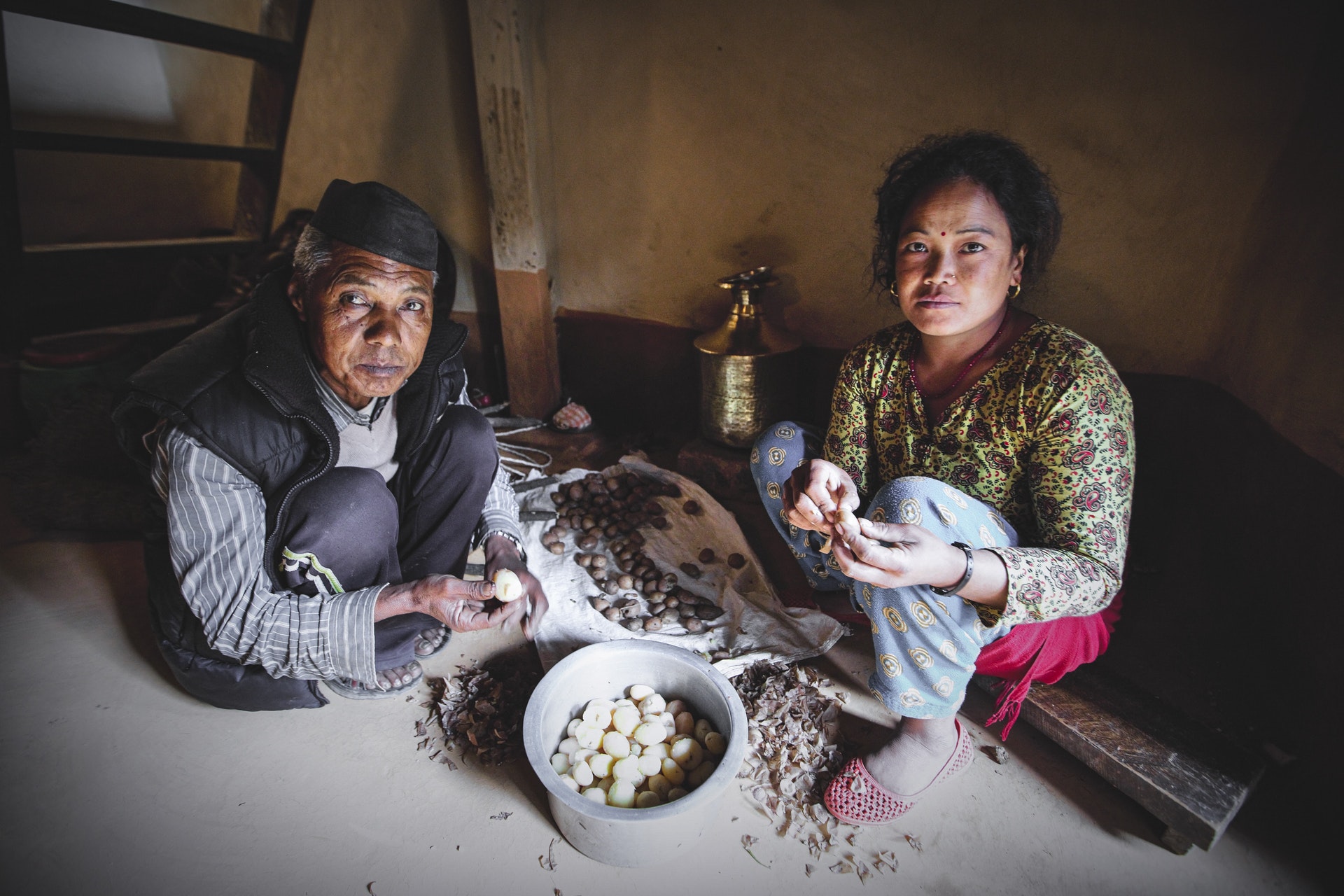 two women sitting on the floor with limited food